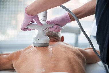 Yaşlı bir adam ultrasonik boşluklarla istenmeyen yağlardan kurtuluyor.