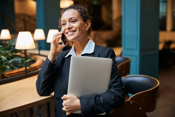 Glad ung kontorsanställd talar per telefon — Stockfoto