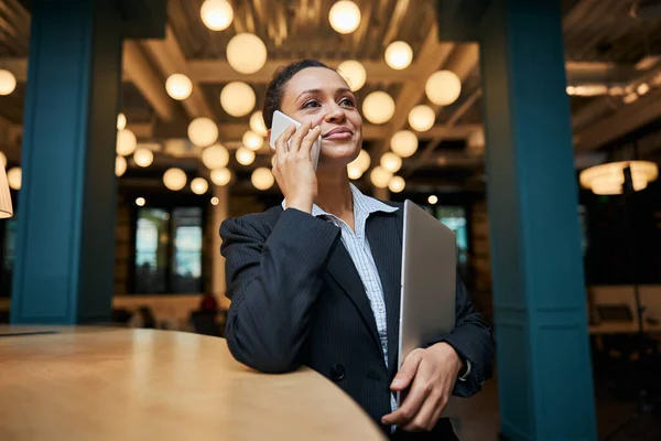 Mujer morena agradable de pie en la mesa — Foto de Stock