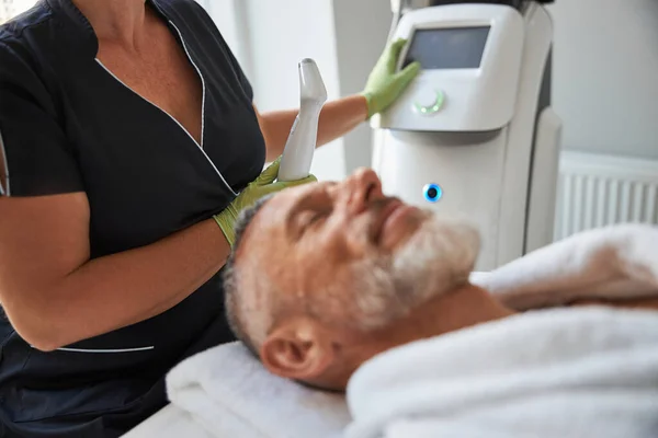 Qualified cosmetician working with a photofacial machine — Stock Photo, Image