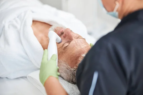Homme âgé passant par la procédure de rajeunissement de la peau au spa — Photo