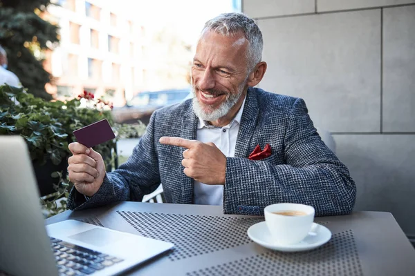 Blij dat een oudere man een kaart demonstreert op een videocall — Stockfoto