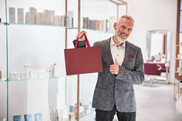 Elegantní starší muž držící vínovou tašku — Stock fotografie