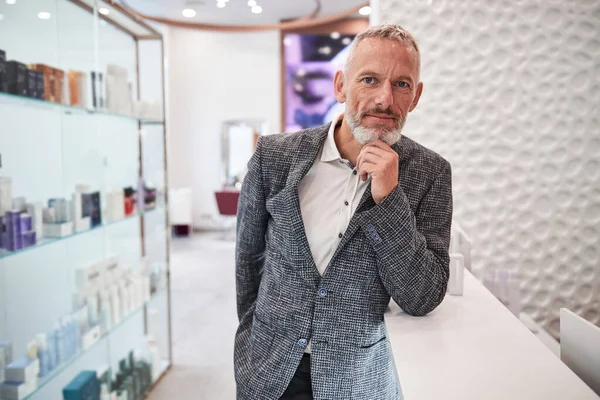 Stylish grey-haired man at a cosmetics store — Stock Photo, Image