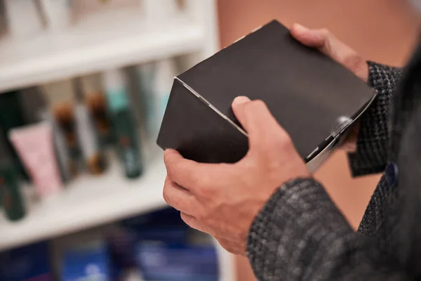 Man at the store with a black box in hands — Stock Photo, Image