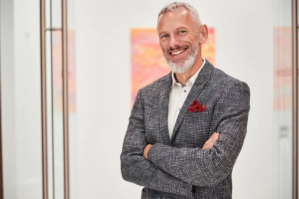 Smiley grey-haired man in a fancy blazer posing indoors — Stock Photo, Image