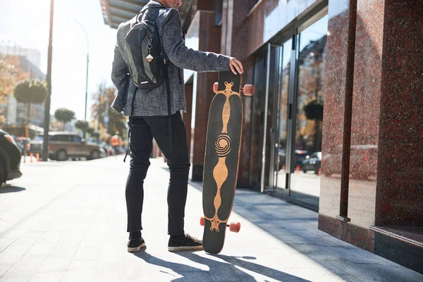 Homem idoso bem vestido posando com um longboard — Fotografia de Stock