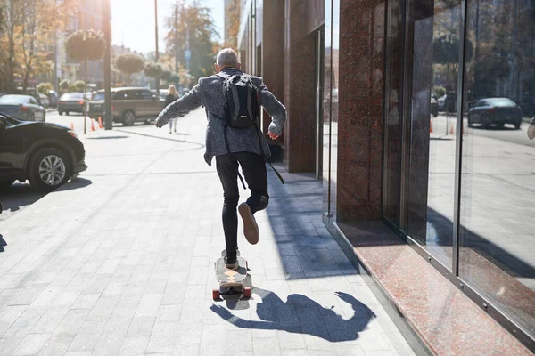 Active senior citizen travelling on his longbaord — Stock Photo, Image