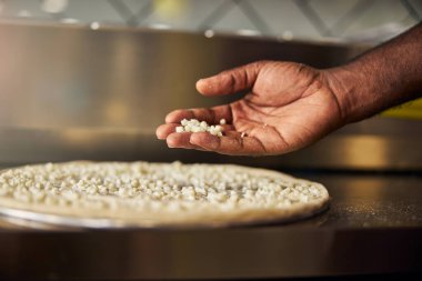 Erkek tencere, profesyonel mutfakta pizza yapıyor.