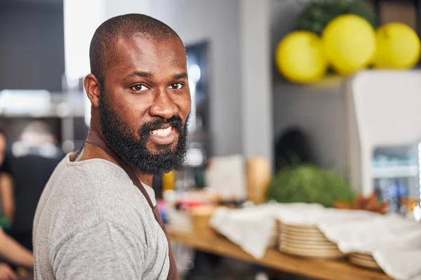 Vrolijke jongeman aan het werk in professionele keuken — Stockfoto