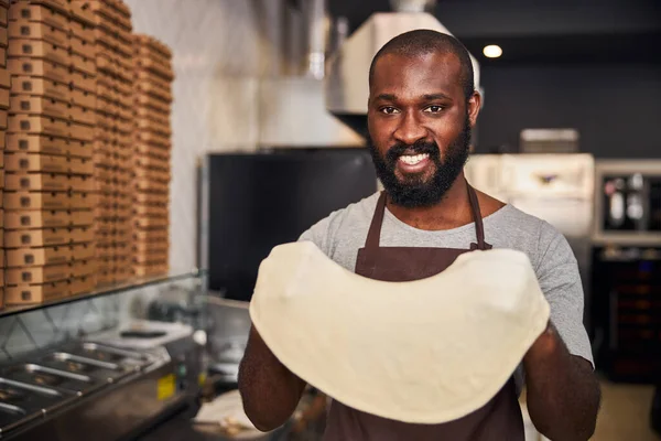 Feliz masculino pizzaiola aproveitando seu trabalho no restaurante — Fotografia de Stock