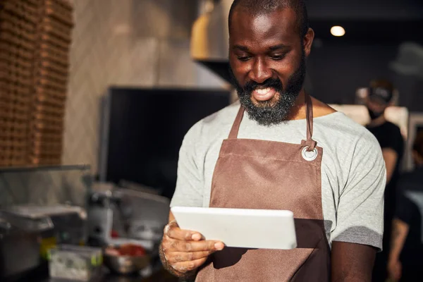 Chef masculino alegre usando tablet na cozinha — Fotografia de Stock