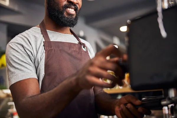 Cantinero alegre masculino usando máquina de café profesional en la cafetería —  Fotos de Stock