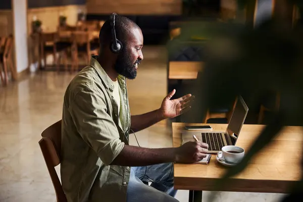 Schöner afroamerikanischer Mann im Gespräch mit Kollegen durch Videoanruf — Stockfoto