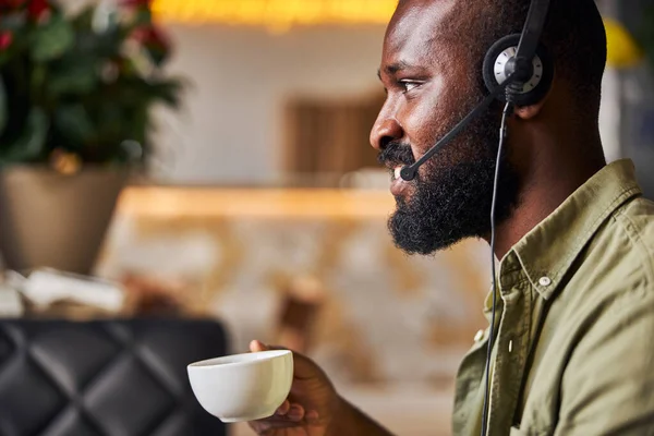 Hombre afroamericano guapo en auriculares bebiendo café —  Fotos de Stock