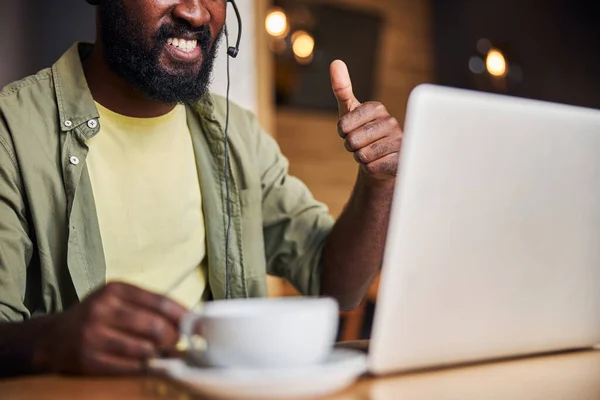 Joyful Afro Amerikaanse man met behulp van laptop en het geven van duimen omhoog — Stockfoto