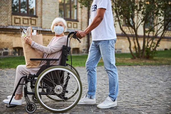 Voluntariado útil caminando con personas discapacitadas al aire libre —  Fotos de Stock