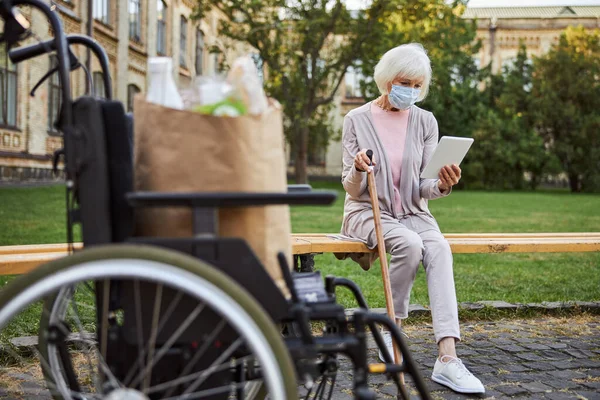 Frau mit Behinderung mit modernem Gerät im Park — Stockfoto