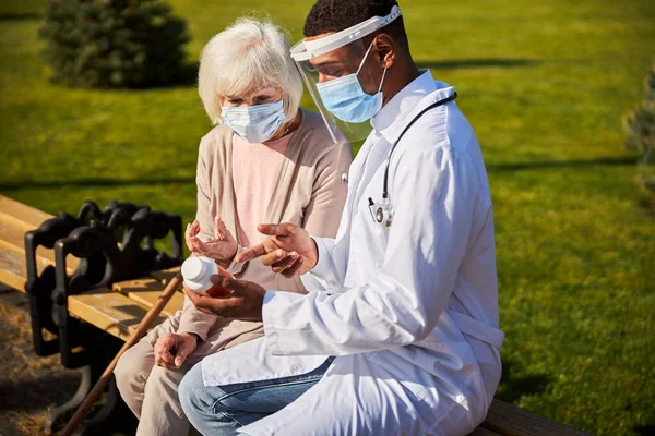 Medical professional demonstrating a bottle of pills