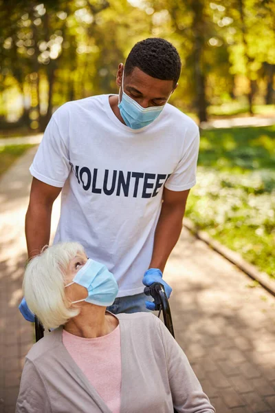 Ehrenamtliche Hilfe für einen erwachsenen Senior während einer Parkfahrt — Stockfoto