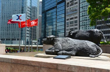 Hong Kong Haziran 2018 yaklaşık. Boğa heykelleri ve uçan dış satım Meydanı, ev, Hong Kong olan şu anda Asya'nın üçüncü büyük borsa borsa bayrakları.