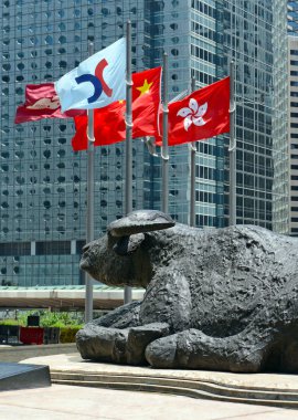 Hong Kong Haziran 2018 yaklaşık. Boğa heykelleri ve uçan dış satım Meydanı, ev, Hong Kong olan şu anda Asya'nın üçüncü büyük borsa borsa bayrakları.