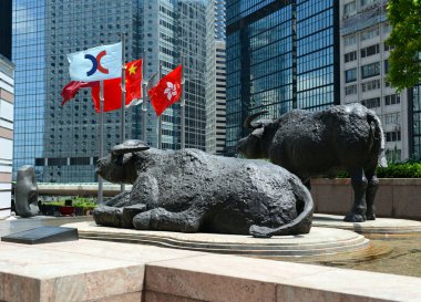 Hong Kong Haziran 2018 yaklaşık. Boğa heykelleri ve uçan dış satım Meydanı, ev, Hong Kong olan şu anda Asya'nın üçüncü büyük borsa borsa bayrakları.