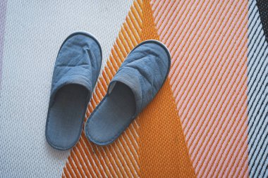 Paspasın üzerindeki gri terlikler..