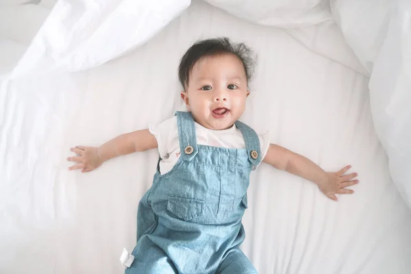 Lächelnd Asiatisch Baby Mädchen Liegend Auf Ein Bett — Stockfoto