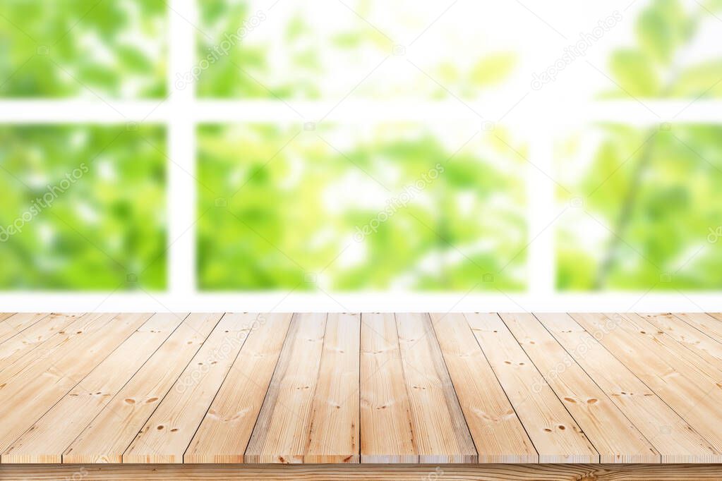 Empty wood table top on blur green leaf garden from window view in the morning. For product display or design key visual layout.