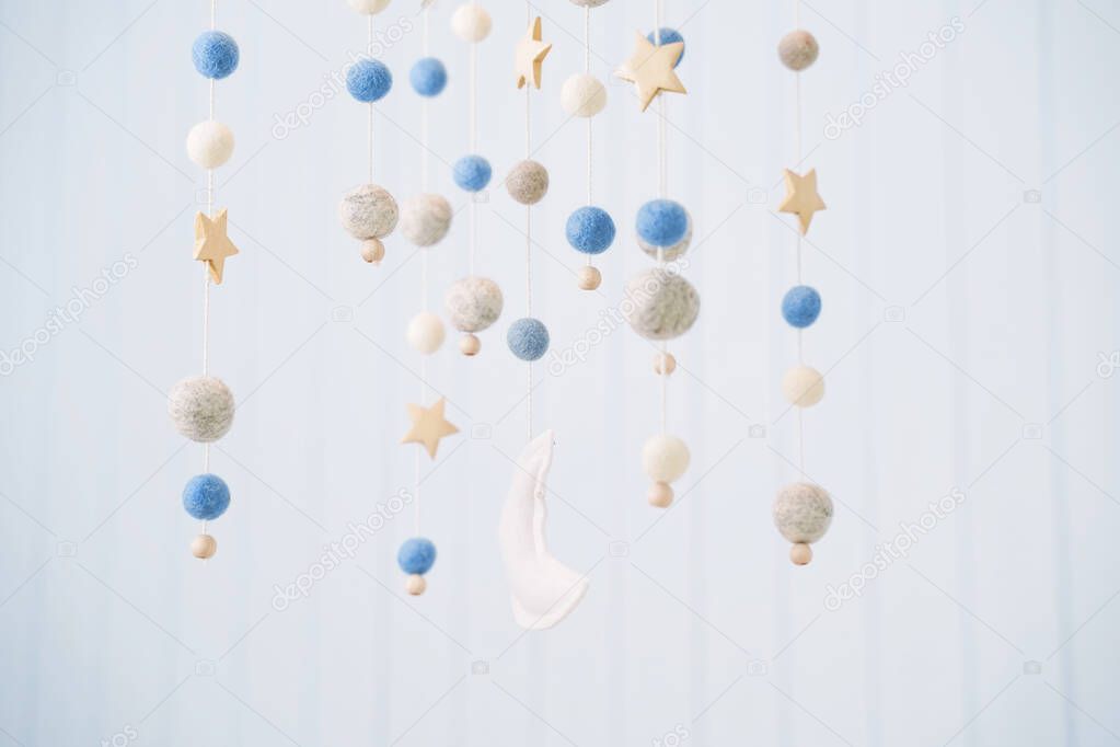 Baby crib mobile. Toys above the baby crib. Hanging soft balls for the child.