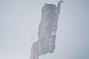 Çimento kaplanmış beyaz duvar onarılmayı bekliyor.