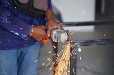 İşçiler çeliği öğütüp metal masayı oluşturuyor. Teknisyen endüstrisi.