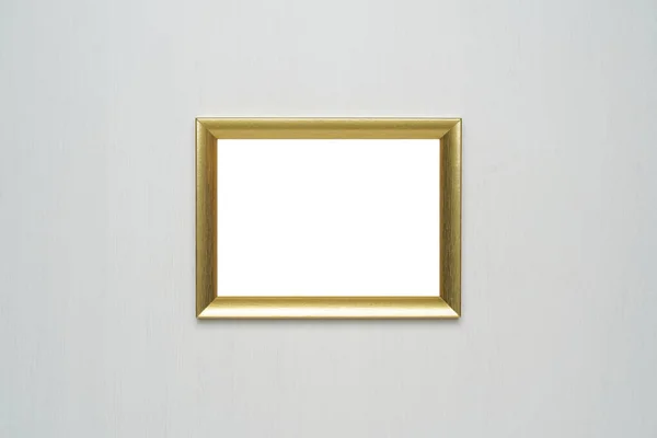 Gold photo frame on white wooden wall.