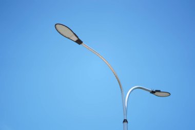 Yolda mavi gökyüzü arka planlı LED sokak ışıkları.