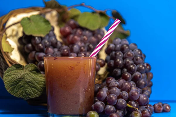 グラスの中のブドウジュース ナイアガラ種のブドウの房 Vitis Labrusca Niagara 青の背景 さわやかな飲み物です ナイアガラのブドウは ブラジルで最も販売されているブドウの種類の一つです — ストック写真