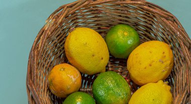 Limonlu hasır sepet. Citrus latifolia. Citrus limonyası. Meyve suyu için ekşi meyve. C vitamini kaynağı. Limonata. Taze meyve. Tropik meyveler.