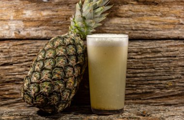 Ananas meyvesi. Bir bardak ananas suyu. Detoks diyeti. Meyve suyu için bitki. Tropik meyveler. Doğal yemek ve detoks. Ahşap arka planda ananas. Tropik bitki. Kral meyvesi.