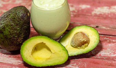 Amerikan persea 'si. Avokado kremi. Tropik meyve. Guacamole. Avokado tam ve yarı yarıya. Yeşil avokado ezmesi. Tatlı. Mutfak lezzeti. Doğal yiyecekler. Yeşil diyet ve detoks. Meyve ezmesi..