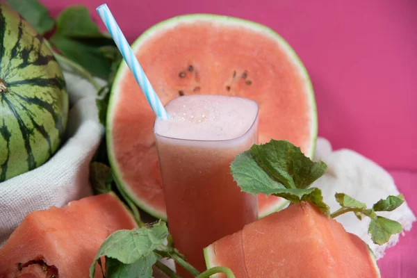 Watermelon Juice and Fruits (Citrullus lanatus). Refreshing drink. Natural juice. Tropical fruit. Fruit drink. Energy cocktail. Detox drink. Natural food. Watermelon juice. Pink background.