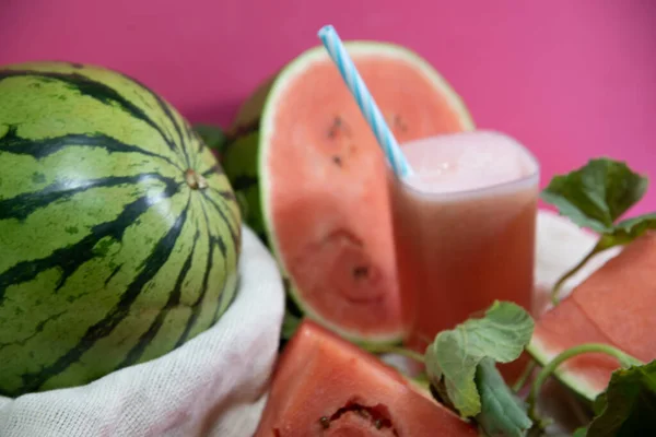 Watermelon Juice and Fruits (Citrullus lanatus). Refreshing drink. Natural juice. Tropical fruit. Fruit drink. Energy cocktail. Detox drink. Natural food. Watermelon juice. Pink background.