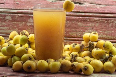Sarı lokuat suyu. İçki ve detoks tazeleniyor. Doğal yiyecekler. Egzotik meyve. Loquat Juice, protein, karbonhidrat, lif, A vitamini ve Potasyum gibi lokuatların ana besinlerini barındırır..