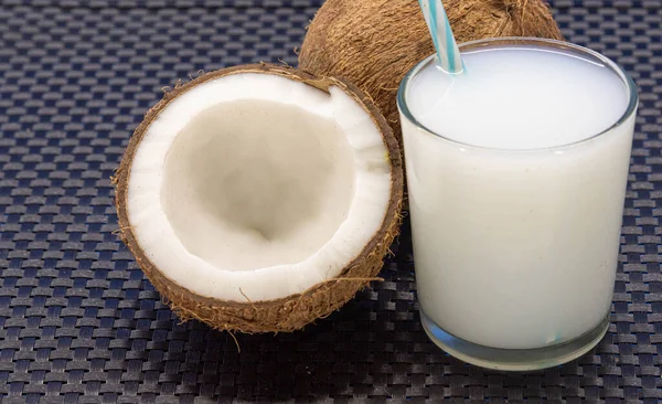 Coconut and glass with coconut water. Coconut water is a sweet-tasting liquid present inside the fruit. Drink is very refreshing and low calorie.