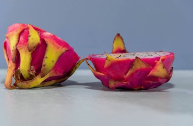 İkiye bölünmüş Pitaya meyveleri. Pitaya, Meksika ve diğer Orta Amerika ülkeleri gibi ülkelerden gelen bir meyvedir. Yine de tatlıdır, az şekerle konsantre olur ve kilo vermek isteyenlere yardım eder..