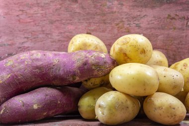 Tatlı patates (Ipomoea patatesi) ve beyaz patates (Solanum tuberosum). Patates ve tatlı patates diyet için bir karbonhidrat kaynağıdır..