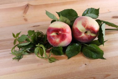 Şeftali ve yapraklar masada