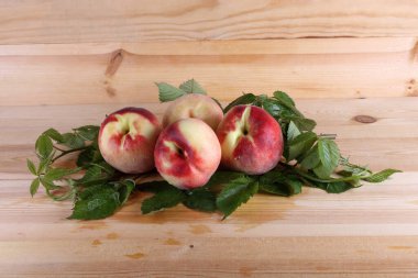 Şeftali ve yapraklar masada