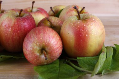 Elma ve yapraklar masada.