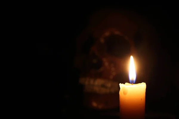 Skull and candle. Black magic. Focus on candle