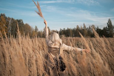Özgürlük için. Sahada duran genç bir kadın, gün batımı